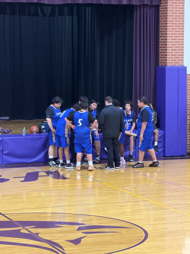 boys basketball team in a huddle with blue jerseys