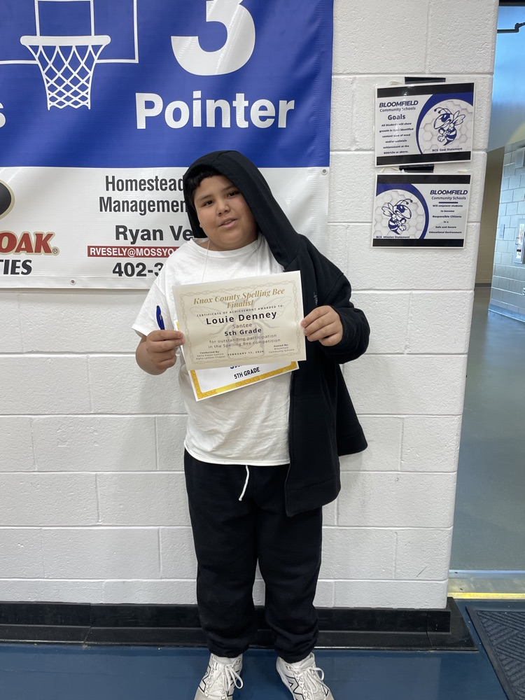 picture of student in white shirt and black pants holding his certificate for the Knox county spelling bee