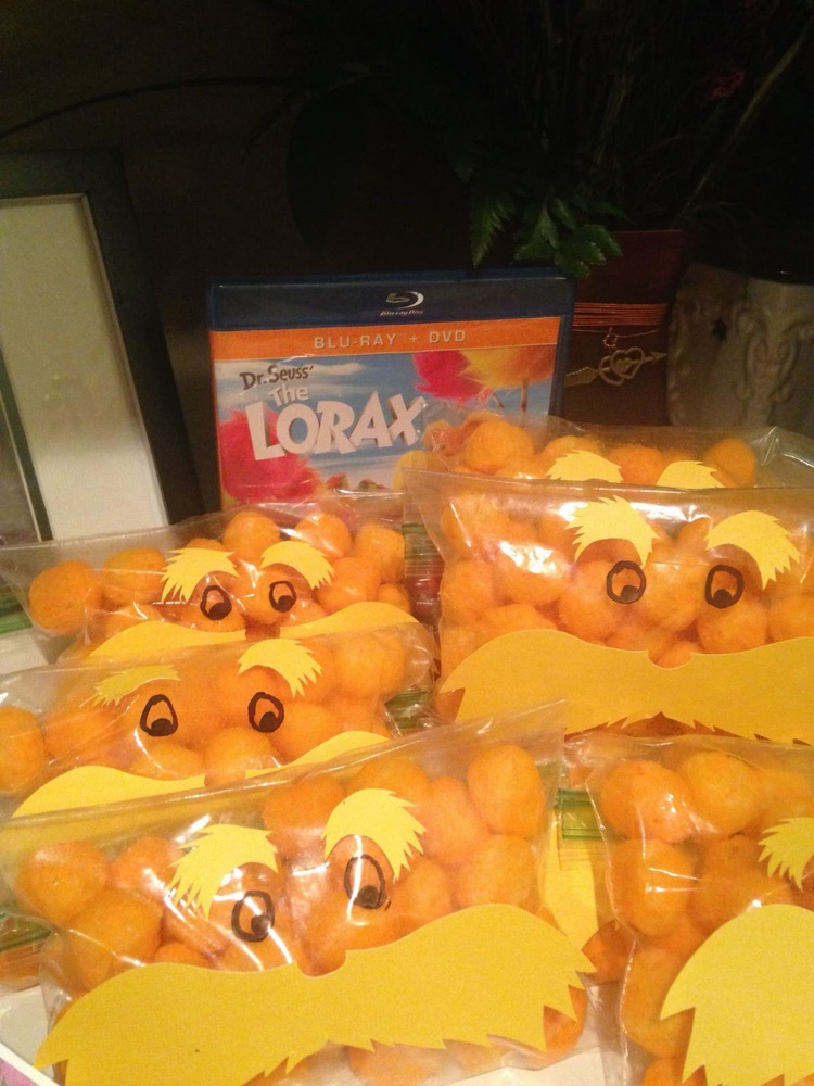 small treats bags filled with orange cheese ball snacks to look like the Lorax.