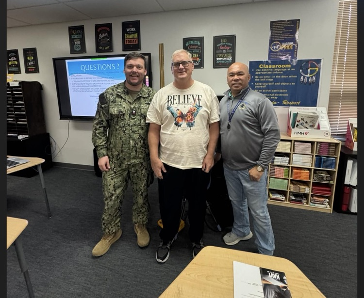 photo of a teacher and two gentlemen in their camouflage army gear visiting a classroom