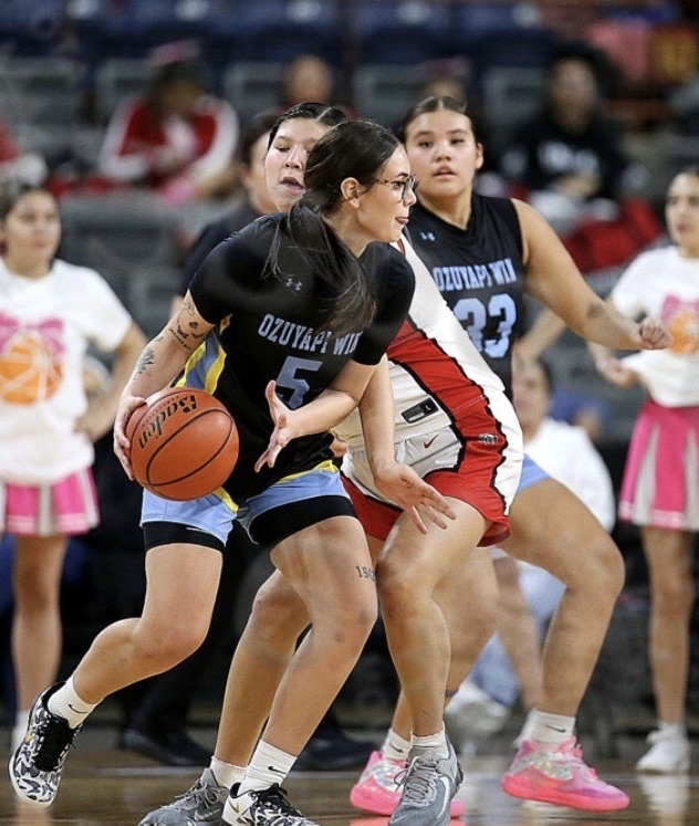 photo of female basketball players, two in black jerseys and two in white jerseys playing basketball against one another 