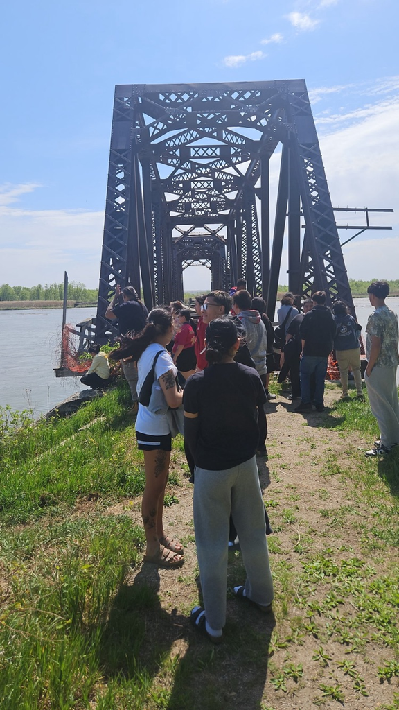 Picture of students standing next to the water and bridge