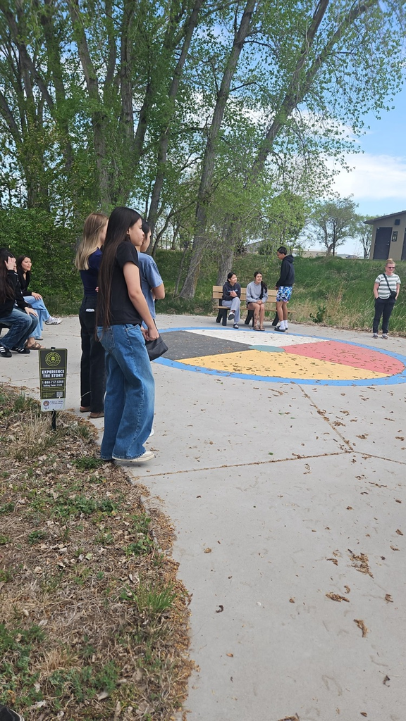 Photo of students standing by a medicine wheel painted on the cement