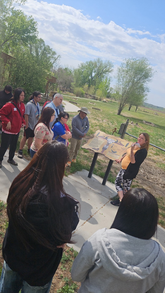Photo of students standing on cement around a park sign that has information about Buffalo