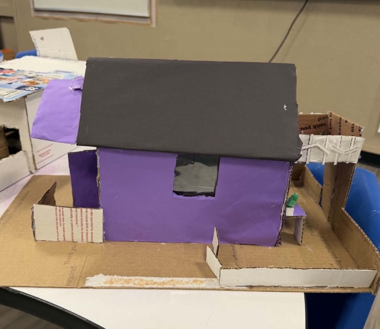 Photo of the middle school math project- building houses out of recycled materials. purple house