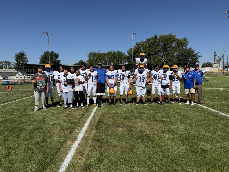 Team picture of Isanti football team with white jerseys on a football field
