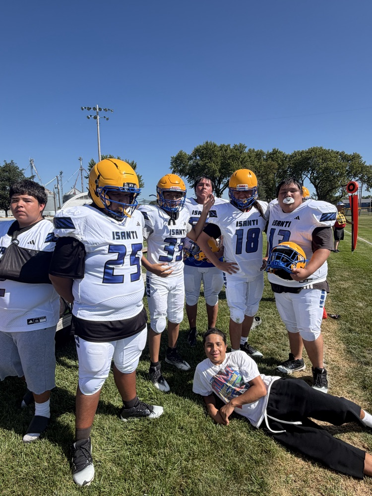 Team picture of Isanti football team with white jerseys on a football field