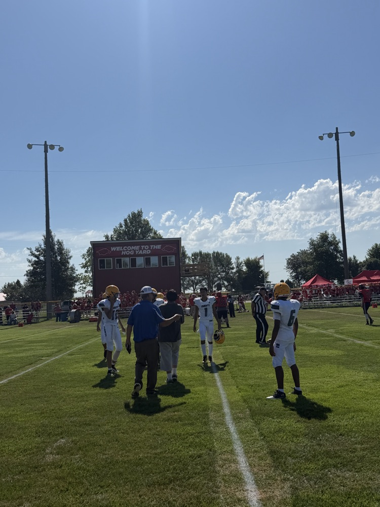 Team picture of Isanti football team with white jerseys on a football field