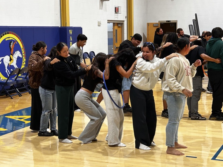 photo of teachers standing in a line playing a game with a hoola hoop