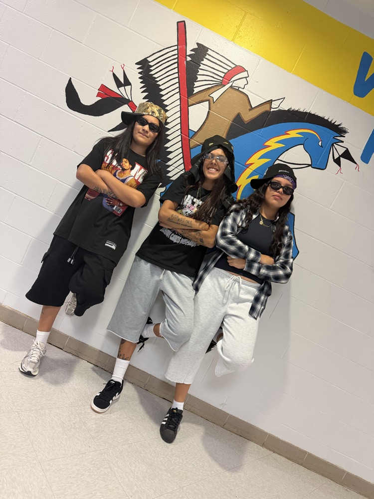 3 female students posing for a picture with their 90s costumes on for homecoming 