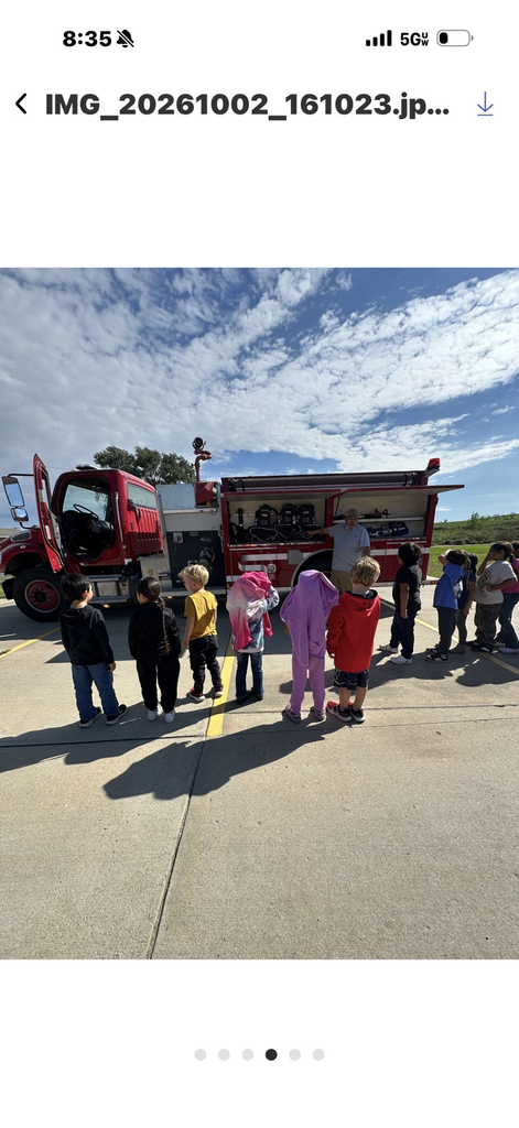 photo of students outside standing in front of a red fire truck 