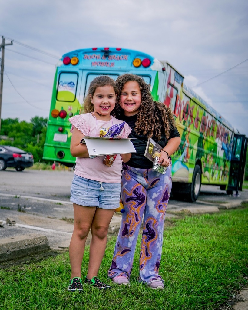 Two students in front of the Book and Snack Mobile