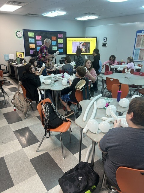 students learning how to make balloon animals and shapes 