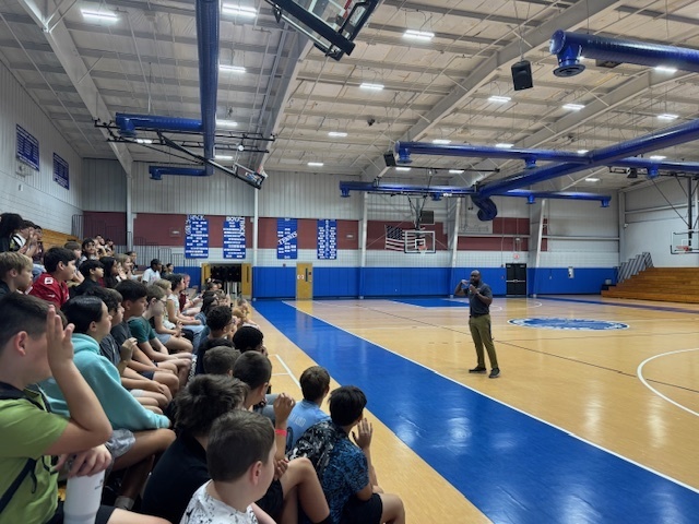 Mr. Lerebours speaking to the 6th grade students in the gym.