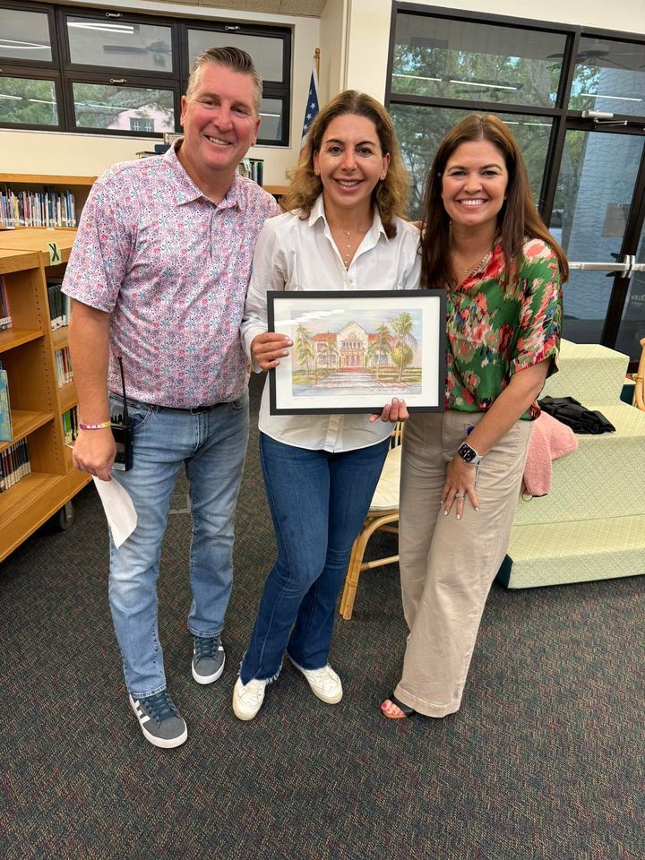 image of 3 teachers holding a painting of a school 