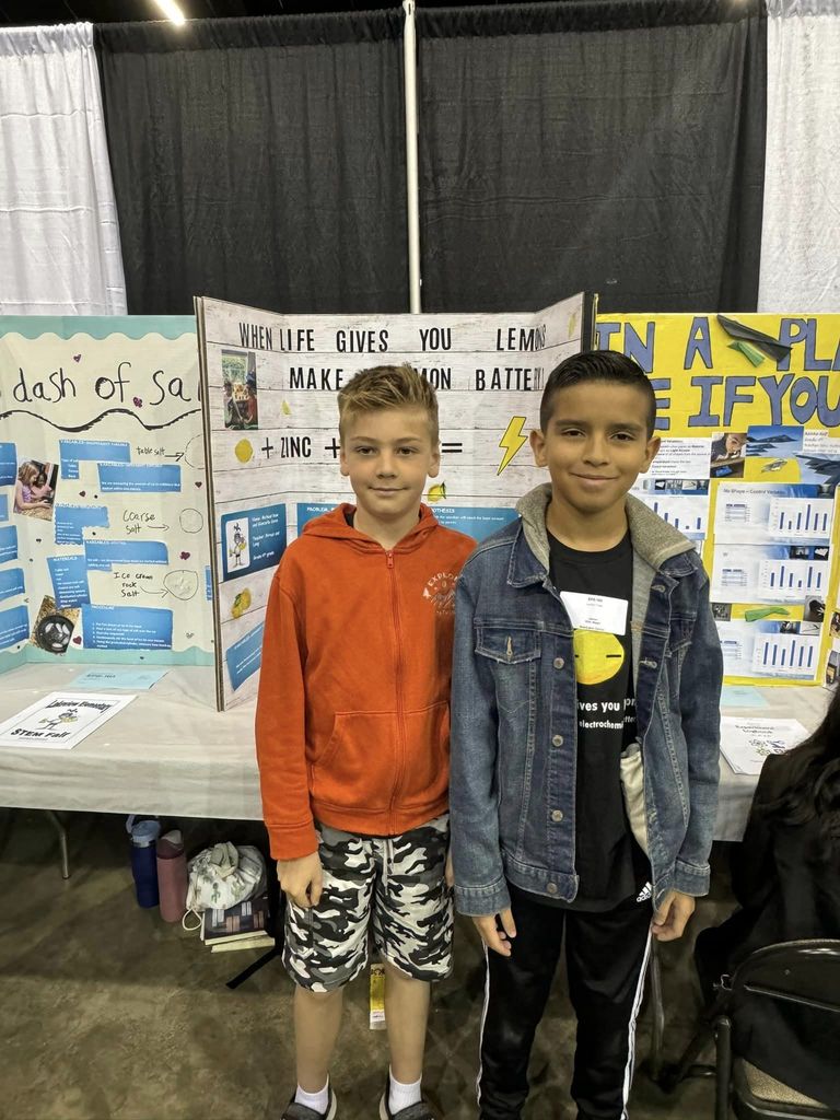 Two kids standing in front of their project