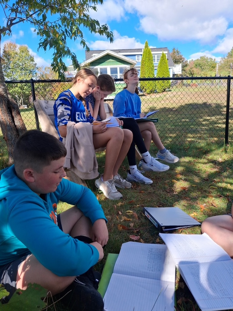 Students writing in the pollinator garden.