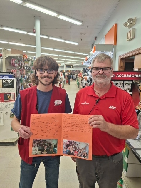 Employees at Ace Hardware holding a thank-you note from our students.