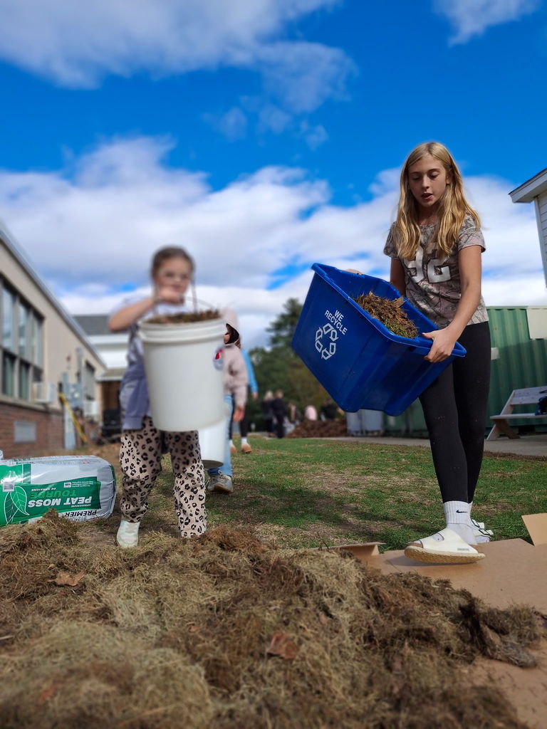 Two students working together to pour soil.