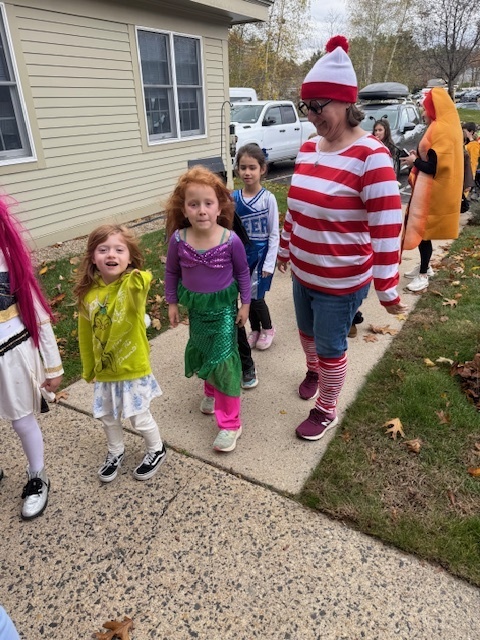 Students dressed in costumes and a teacher dressed as Waldo parading into Poplin.