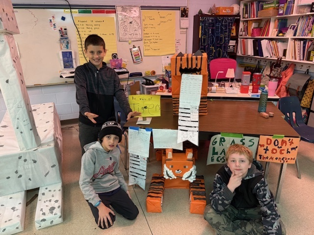 Students posing with their tiger volume zoo projects.