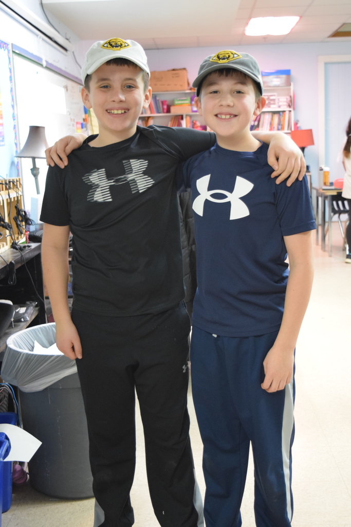 Two students twinning in under armour sweatsuits and hats.