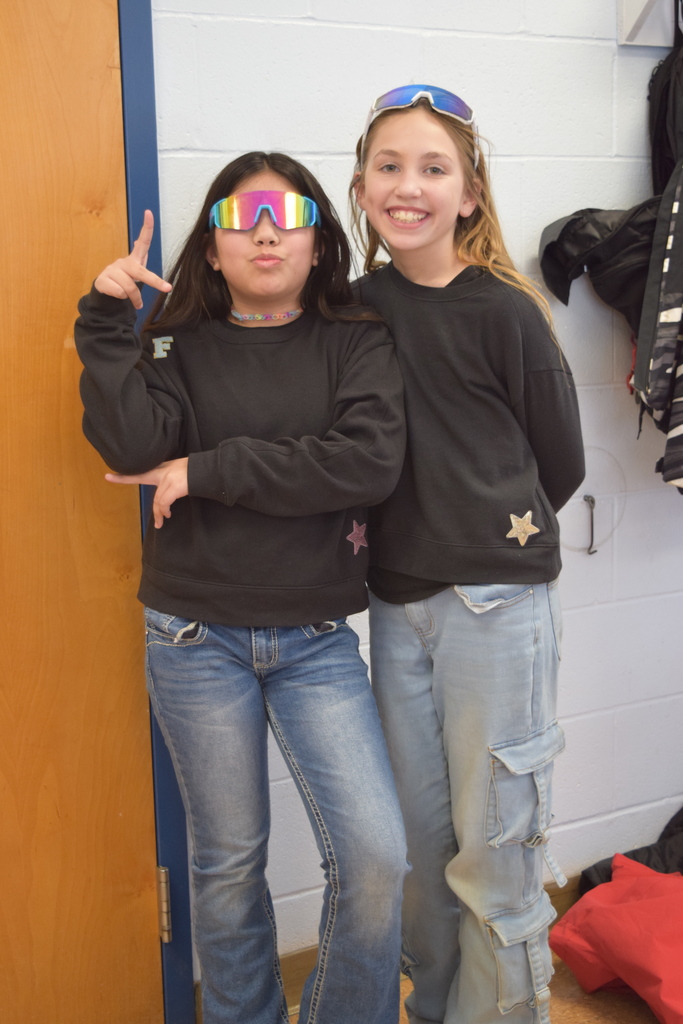 Two students twinning in black sweatshirts and jeans.
