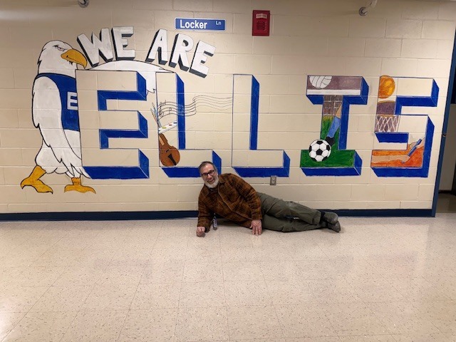 Mr. Fernandes posing in front of our new mural: "We are ELLIS" with an eagle next to it
