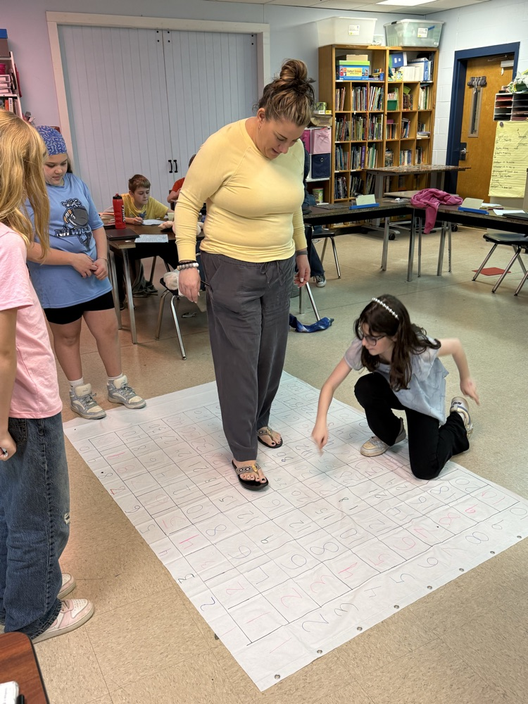Students teaching Ms. Perkins how to use the mat.