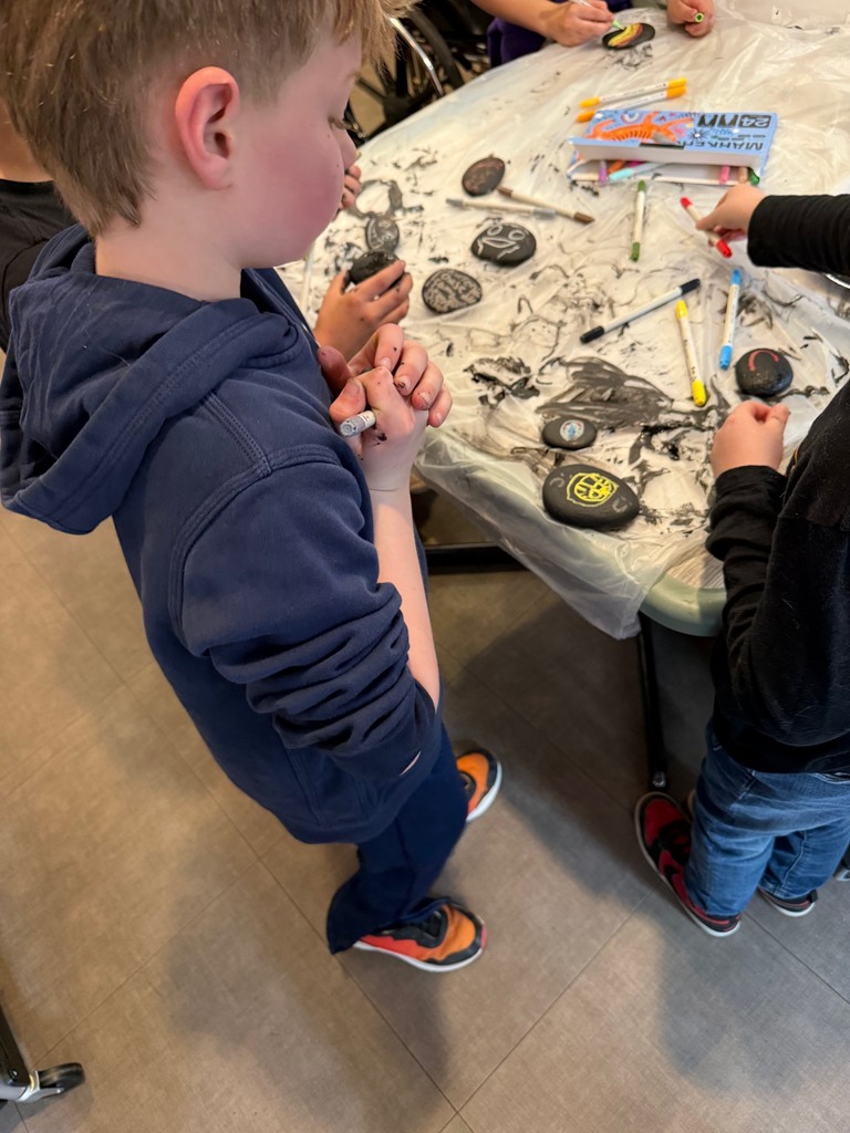 Students painting rocks with Poplin residents