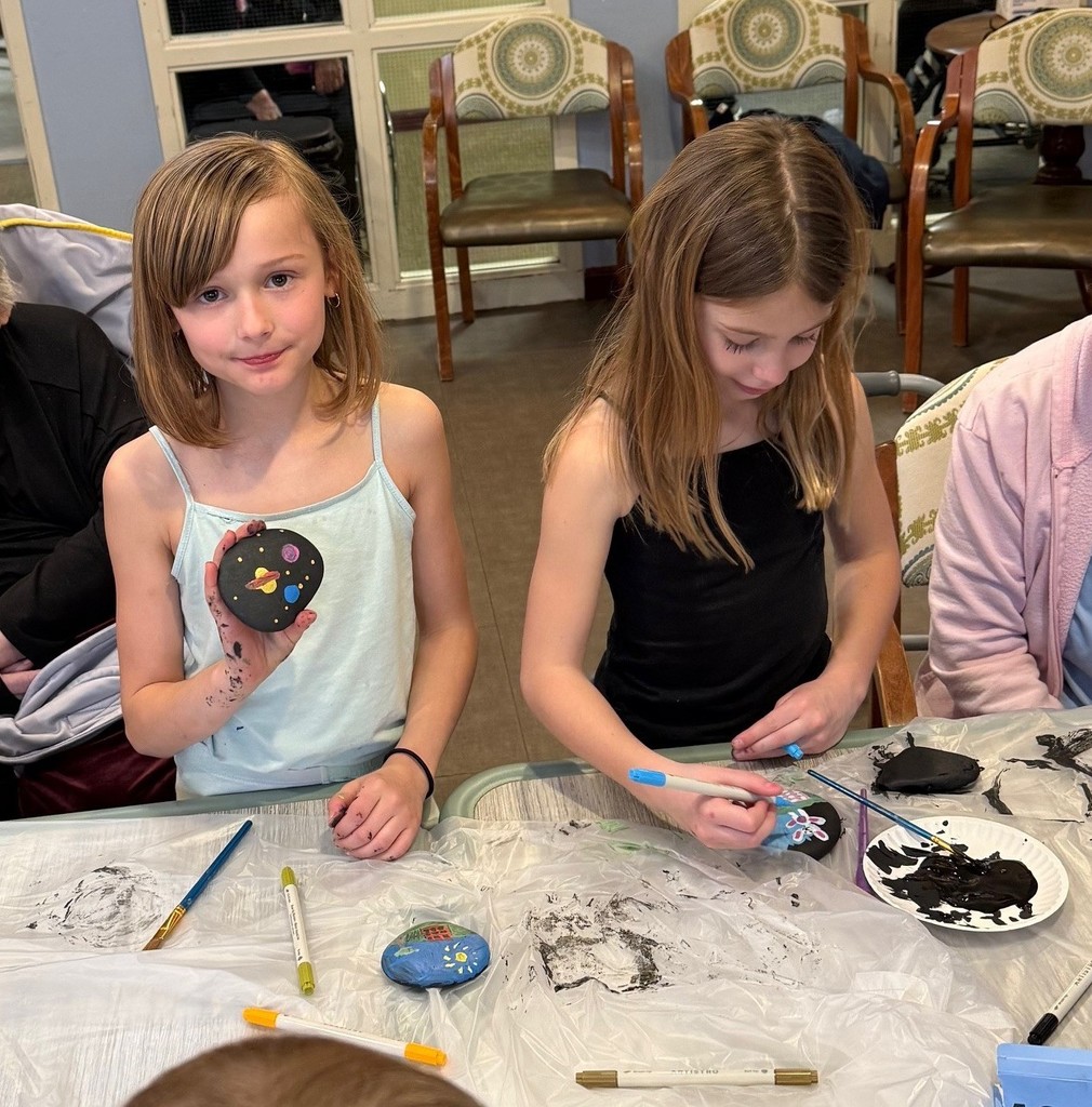 Students painting rocks with Poplin residents
