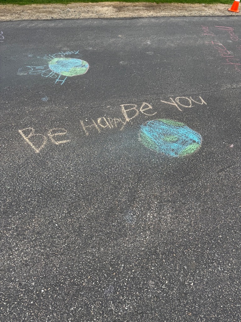 A student chalk message: "Be happy. Be you."