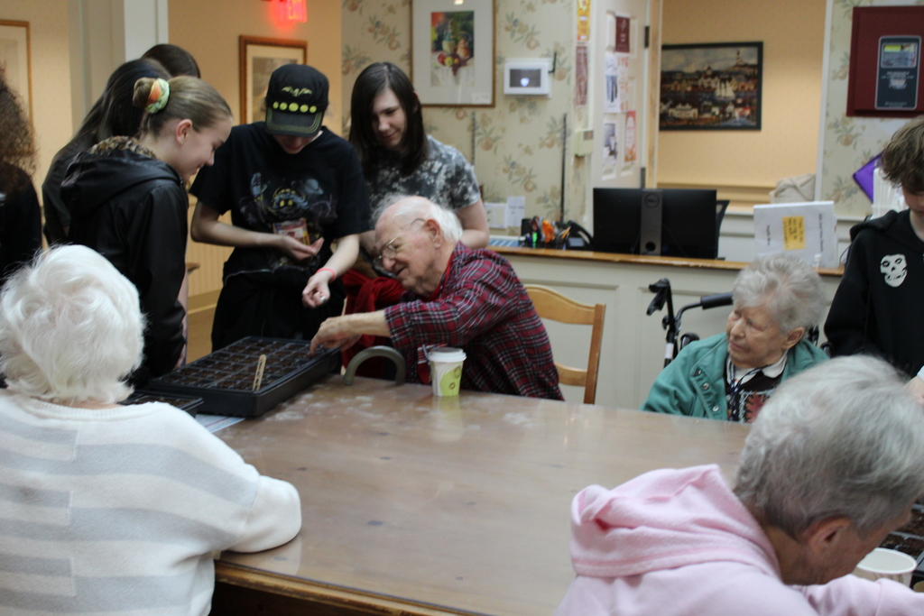 Students helping to plant seeds with Poplin residents