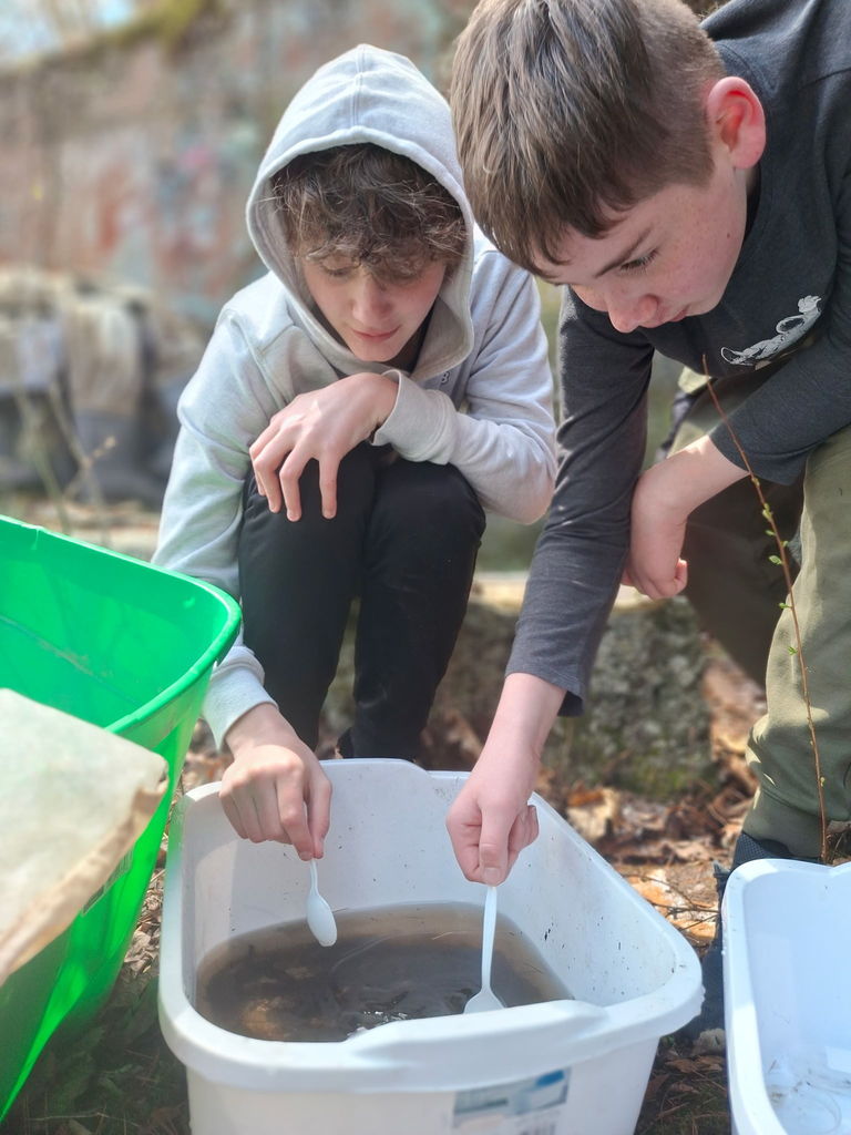 Two students exploring the water and its critters