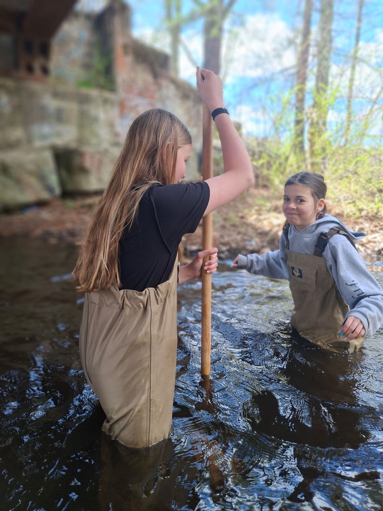 Two students in the river with waders on!