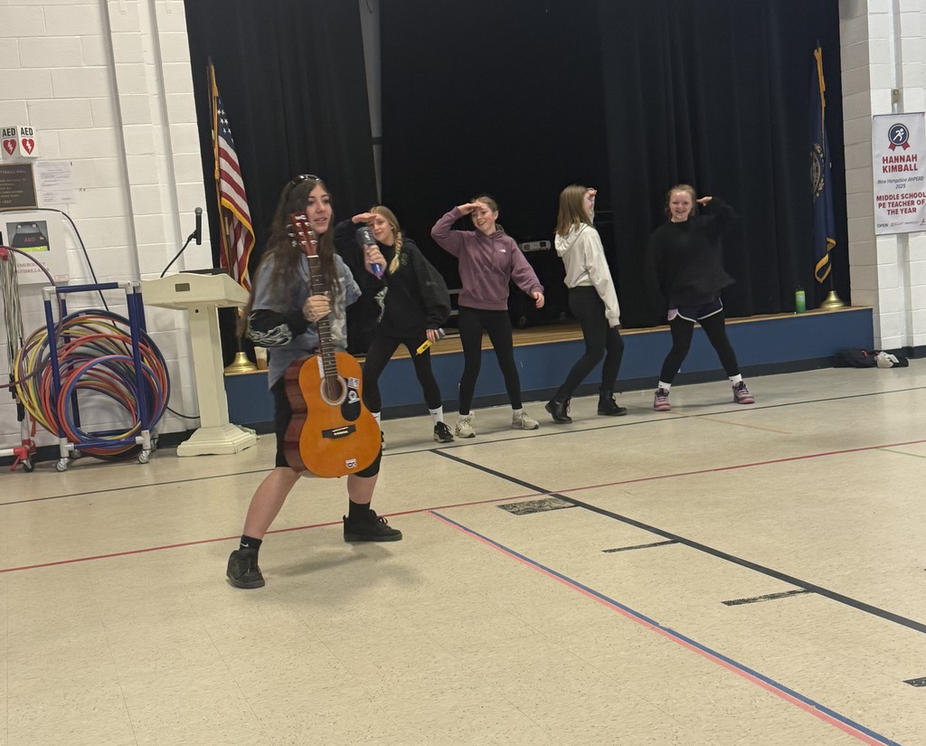 Five students dancing; one has a guitar