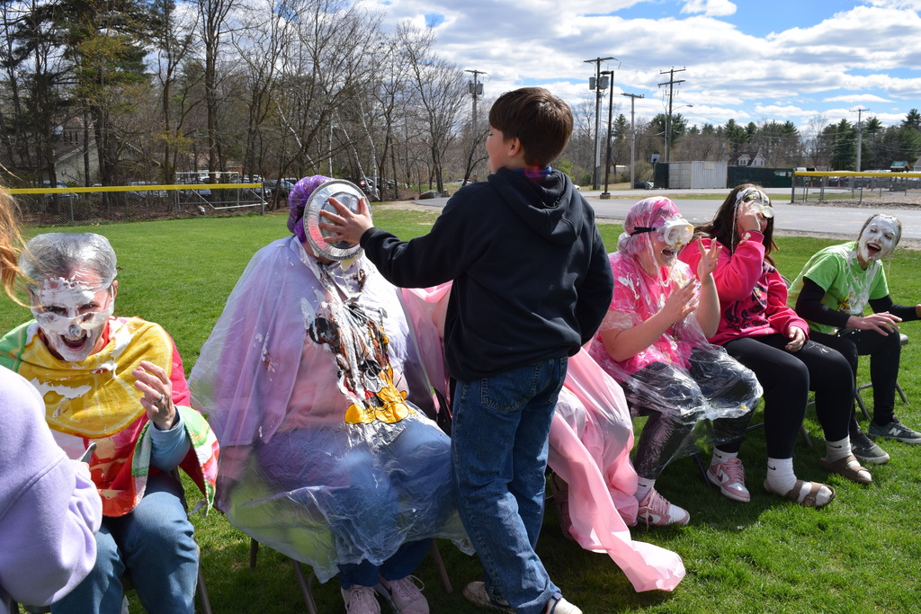 A student pieing a teacher, their grandmother, in the face!