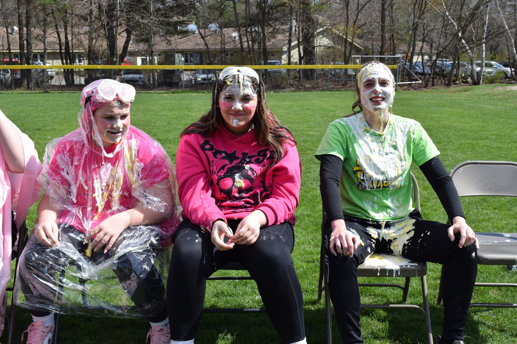 Two students and Mrs. Kimball posing with pie on their faces.