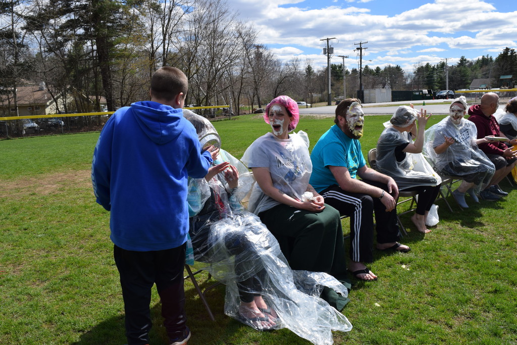 A student pieing a teacher, their mother, in the face! Mrs. Rosenberg looks on with a shocked, pie-covered face.