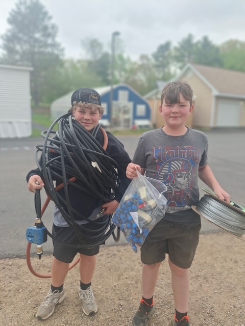 Two students posing with the hose and installation tools