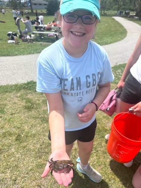 A student smiling with a crab