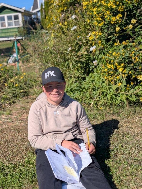 A student smiling while completing his journal entry
