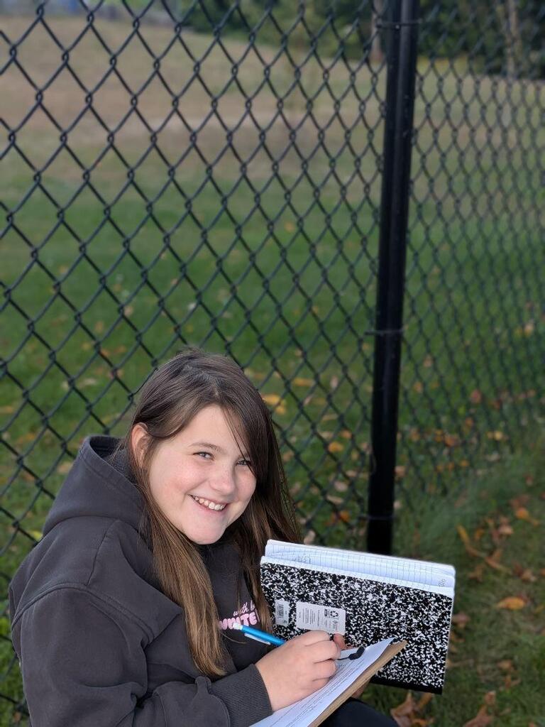 A student smiling with her science notebook