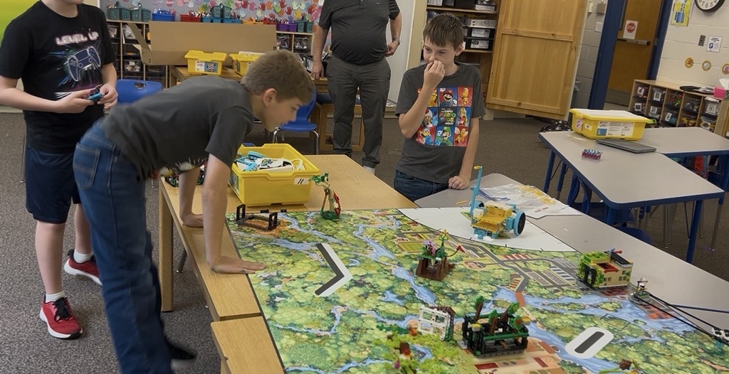 Four students problem-solving the coding for their robot