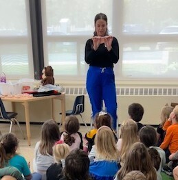 Mrs. Therrien showing students how to brush their teeth