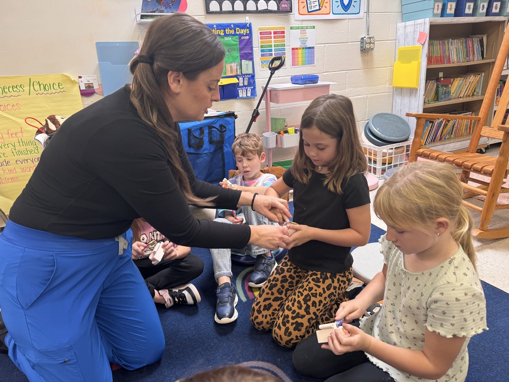 Two students practicing flossing with Mrs. Therrien