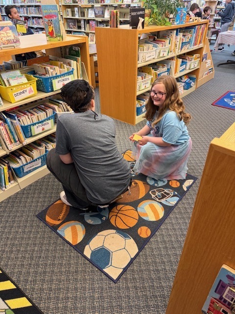 A student looking for books with Ms. Drake's daughter.