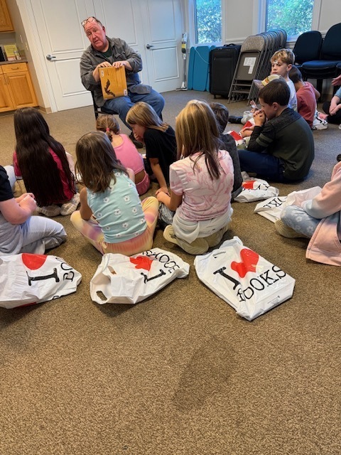 Students listening to Mr. Eric read a story.