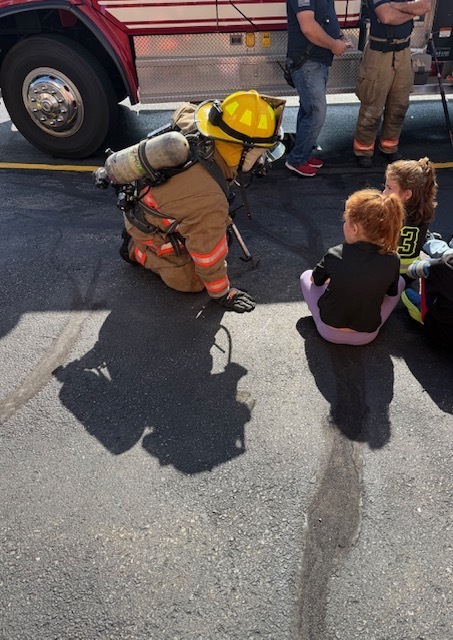 Interacting with students in firefighter gear so that they know what firefighters look like when they arrive to the scene.