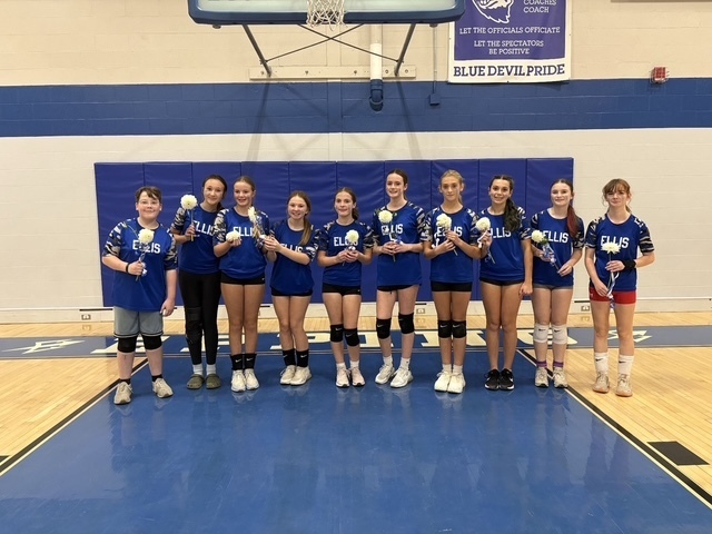 8th grade volleyball players holding flowers